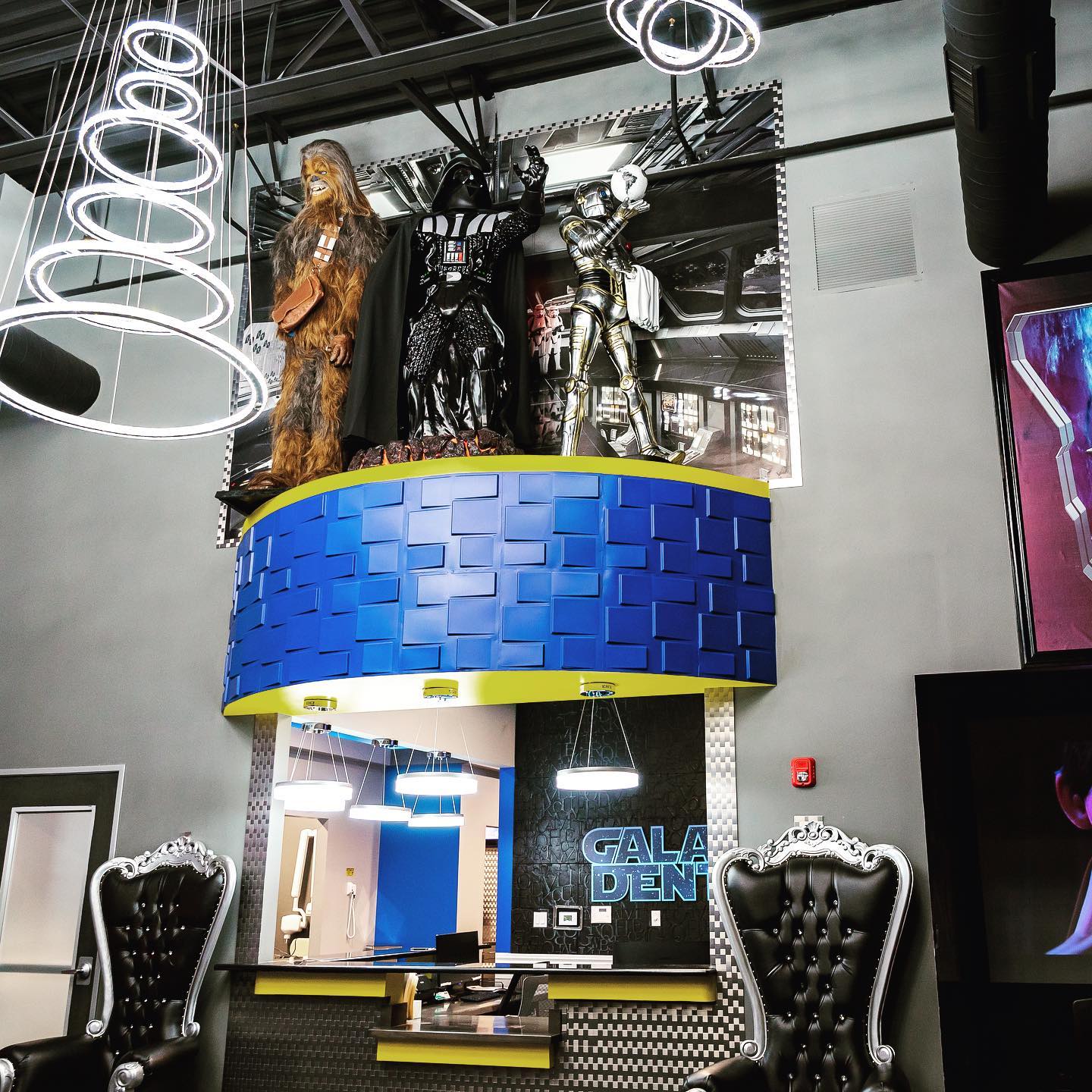 A statue of darth vader and chewbacca hangs from the ceiling of a restaurant