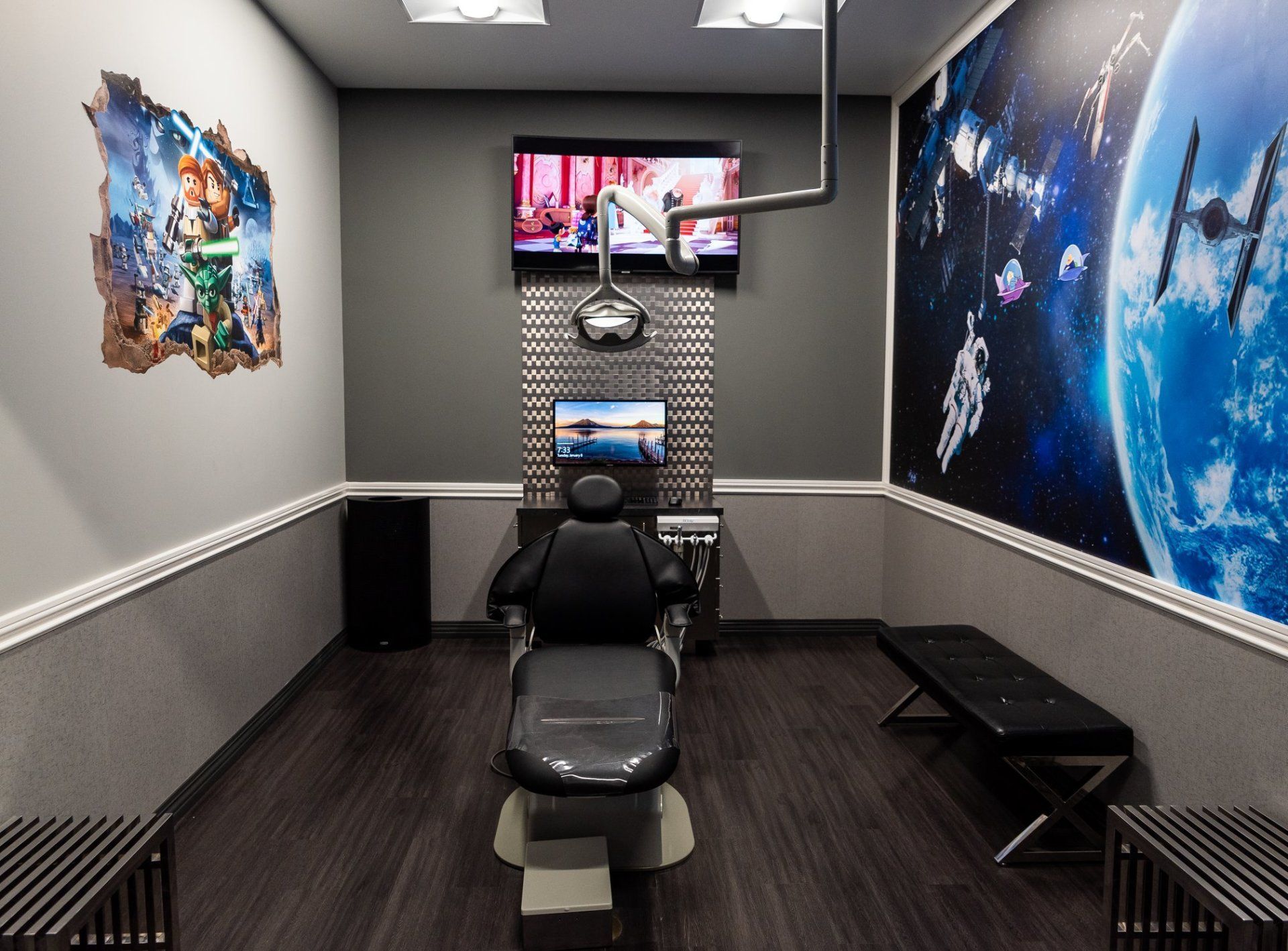 A dental office with a dental chair and a television on the wall.