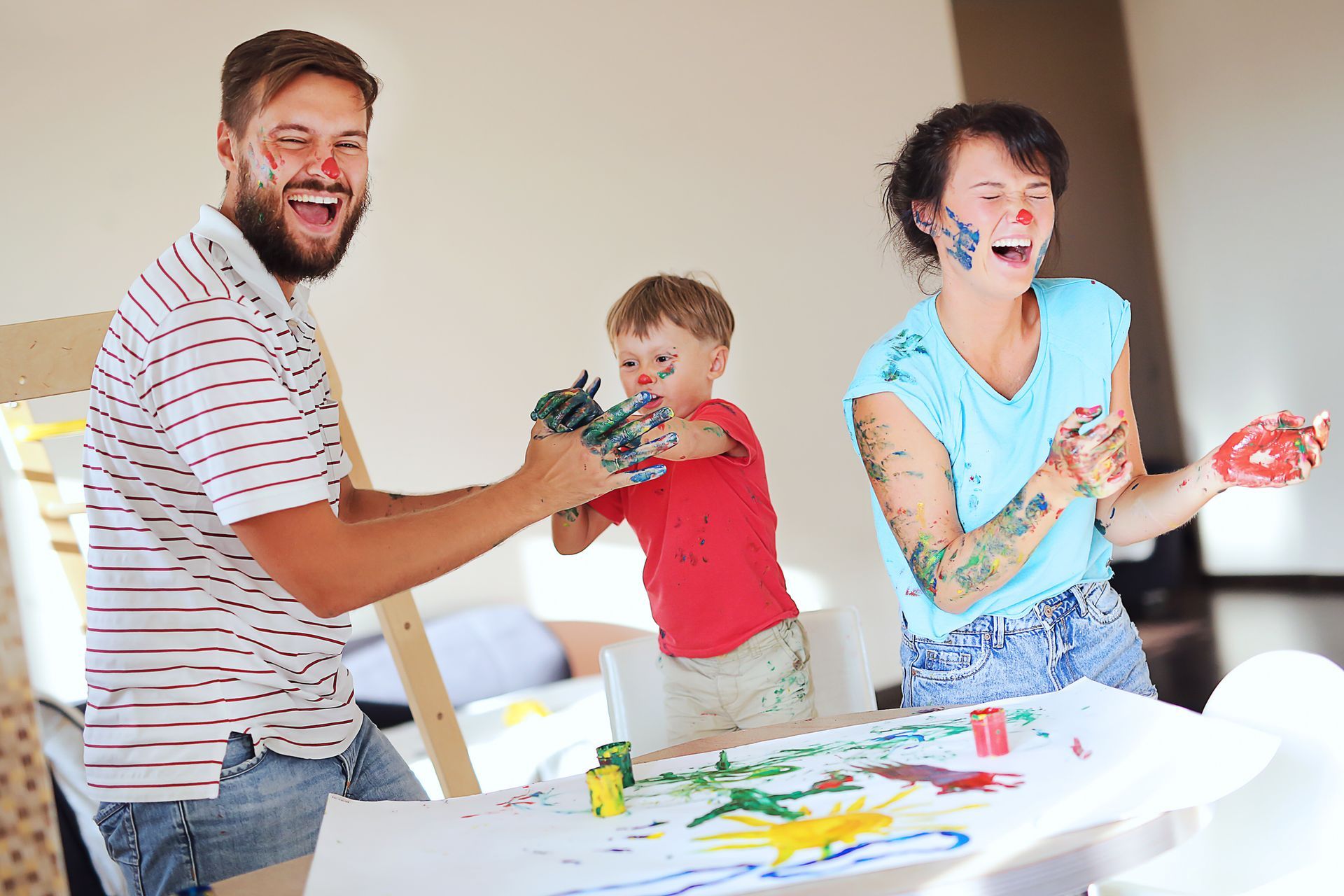 A family is playing with paint on a table.