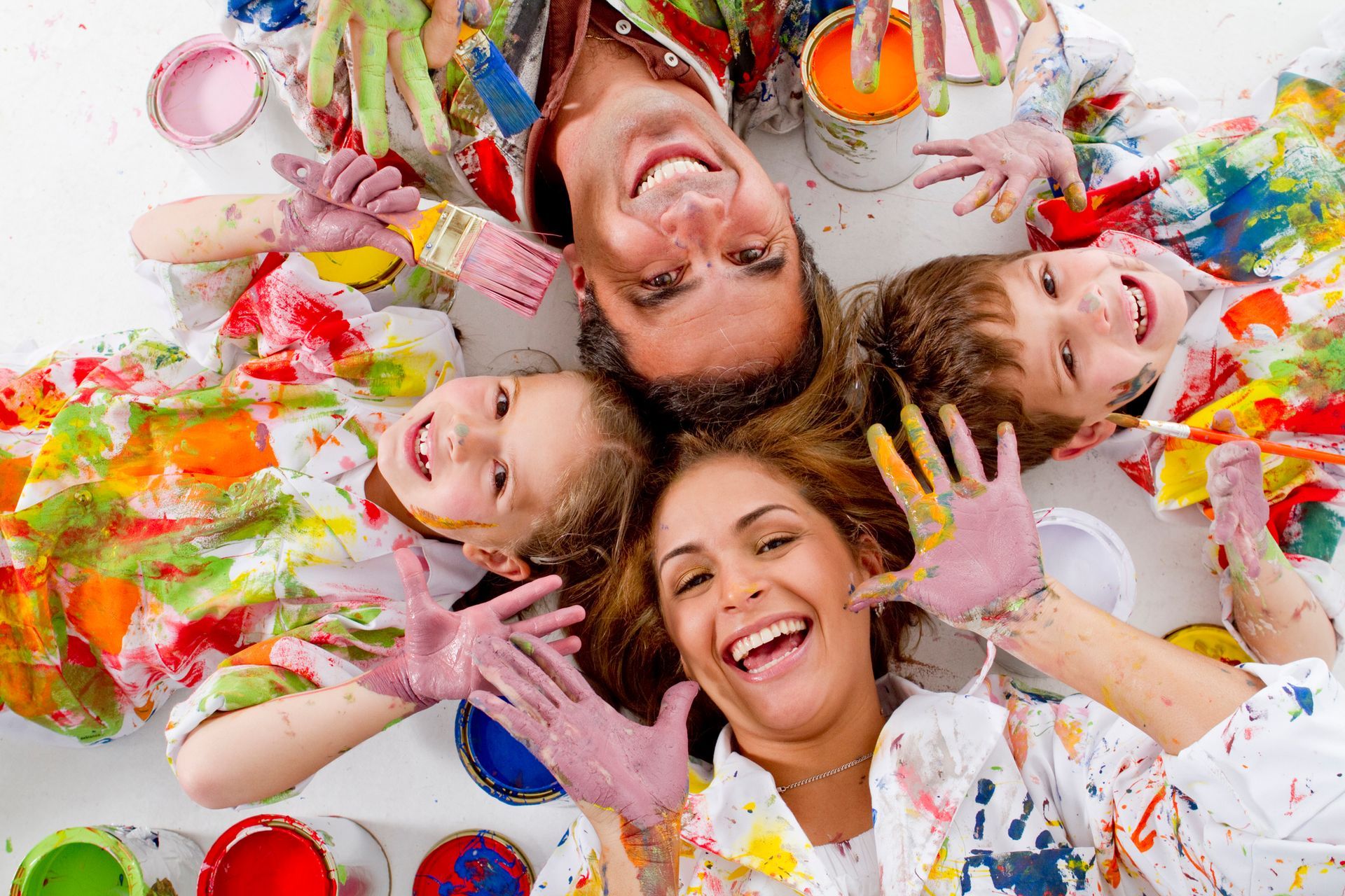 A family is playing with paint on a table.
