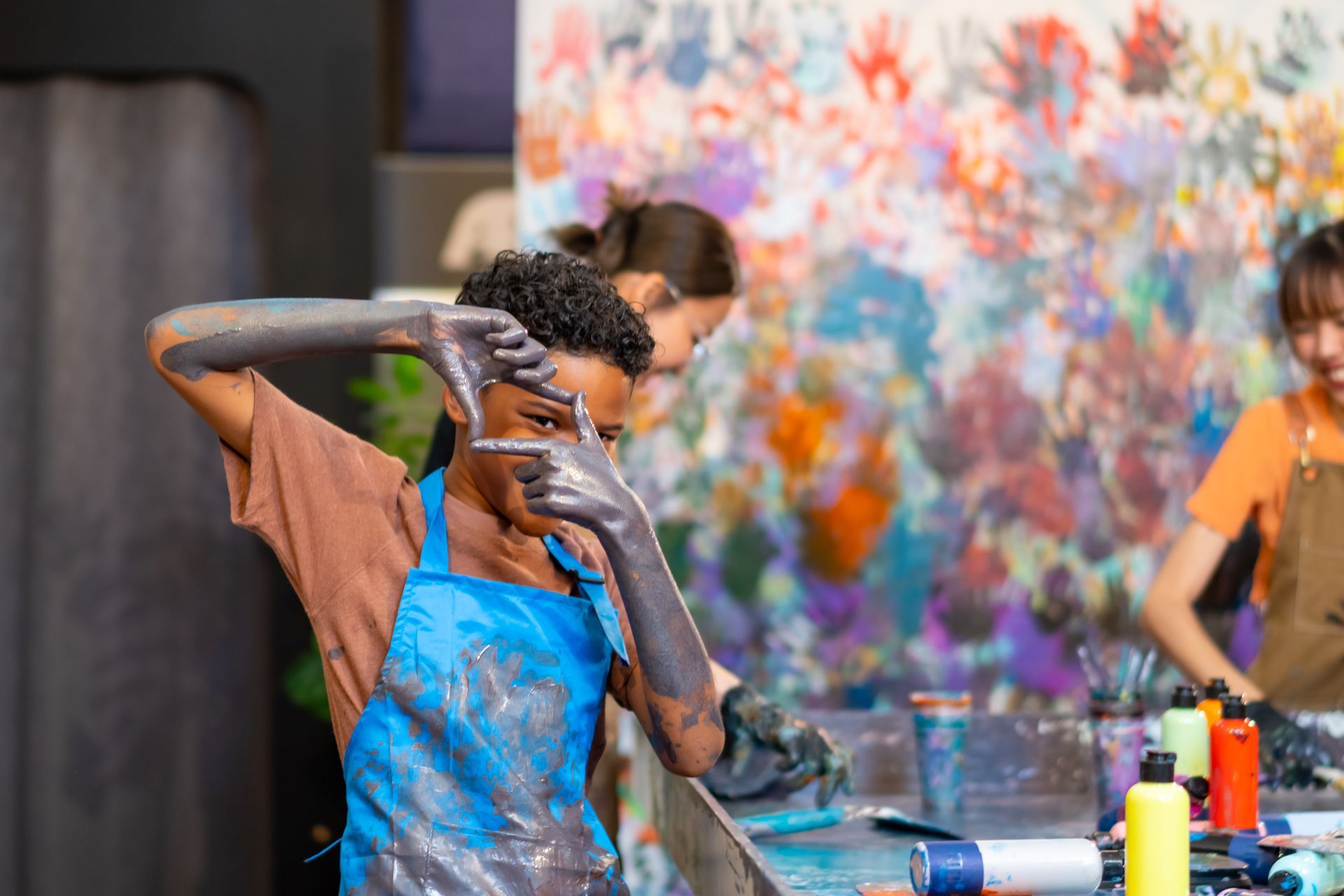 Two young girls are painting on a wall in a room.