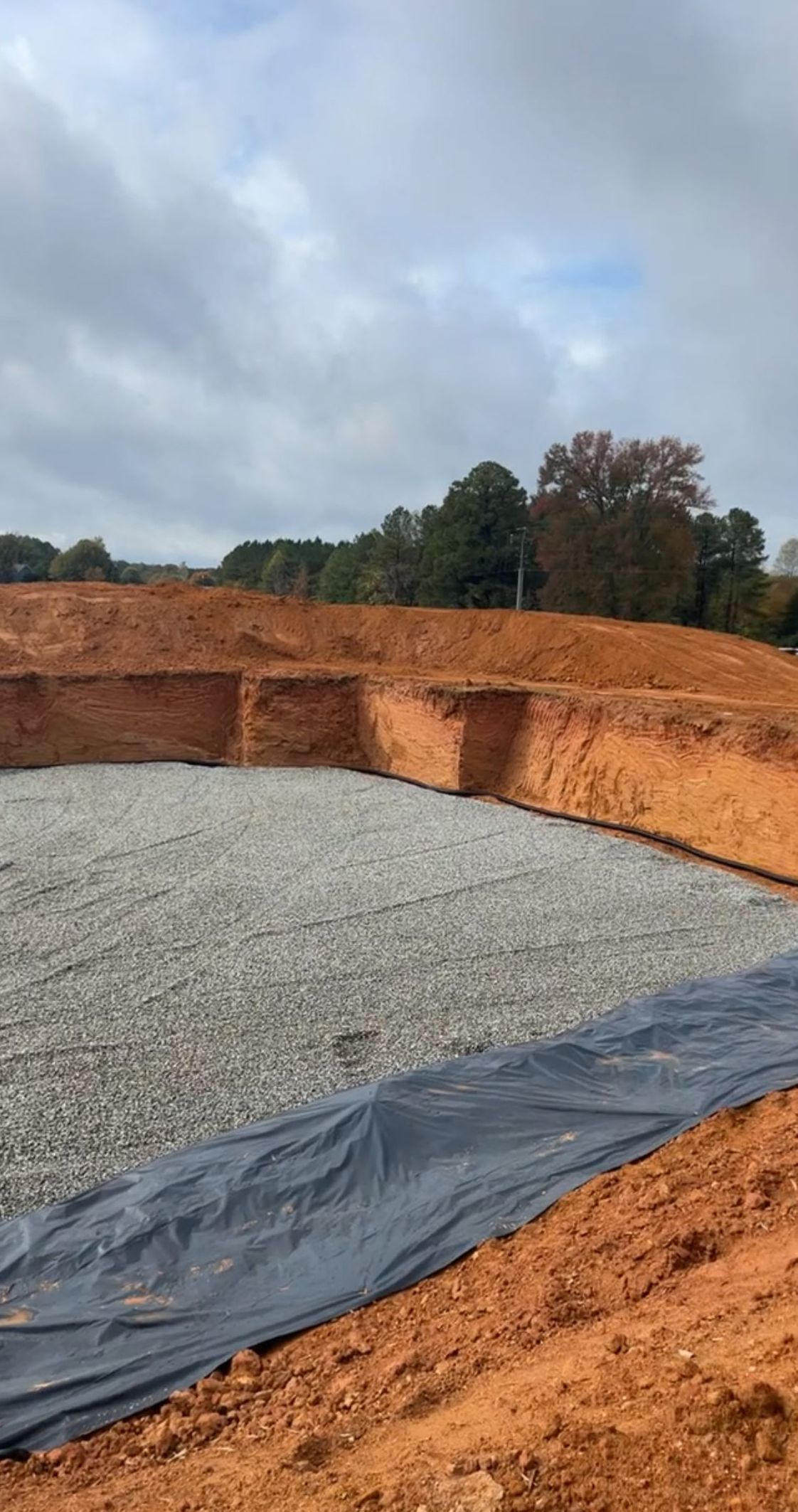 A large pile of dirt and gravel is sitting on top of a dirt field.