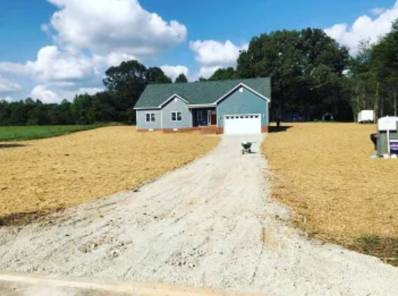 A house with a gravel driveway leading to it