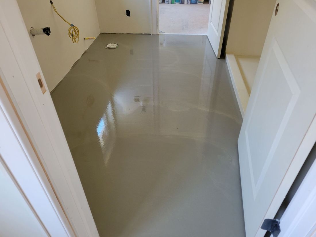 a hallway with a gray floor and a white door