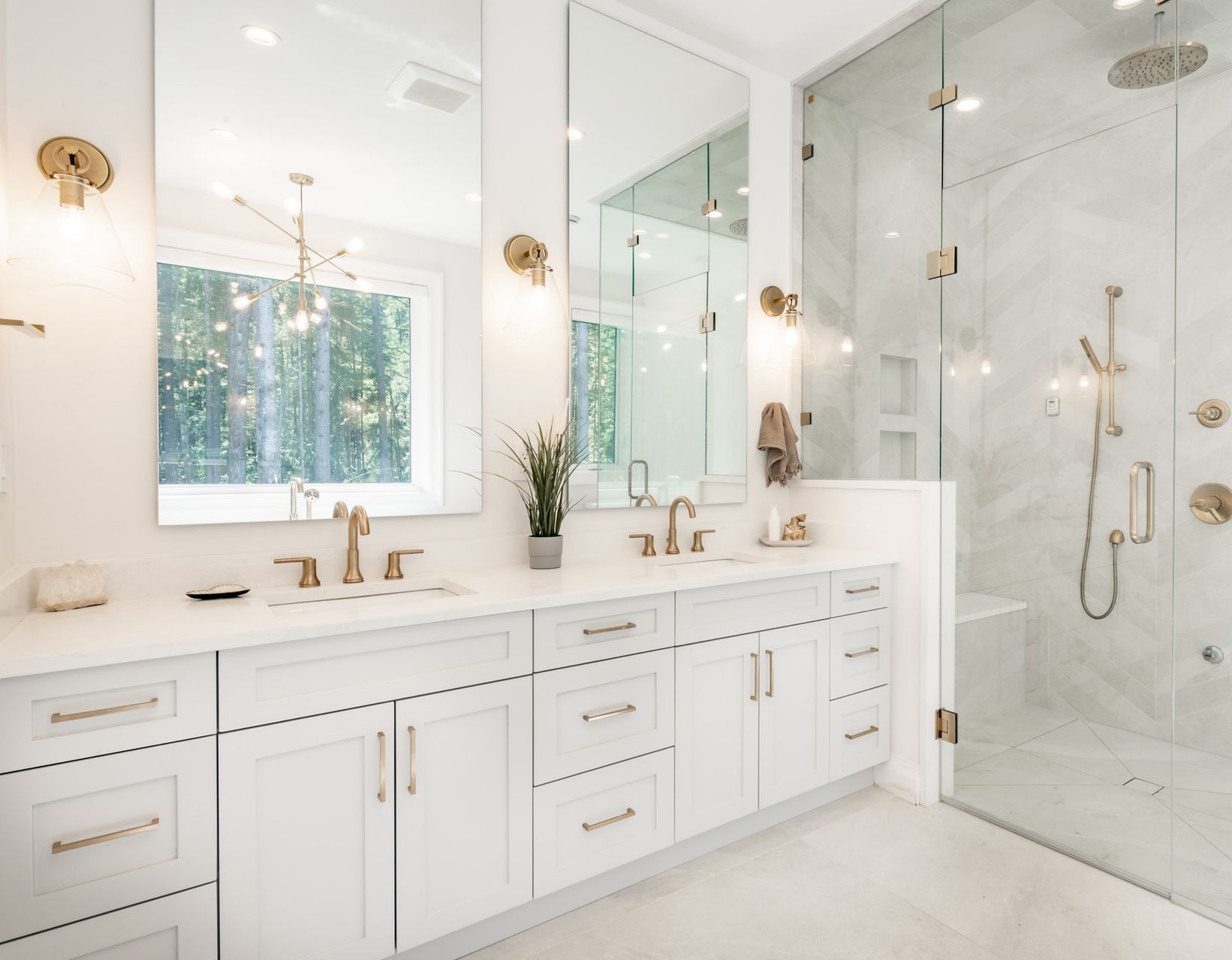 A bathroom with two sinks and a walk in shower.