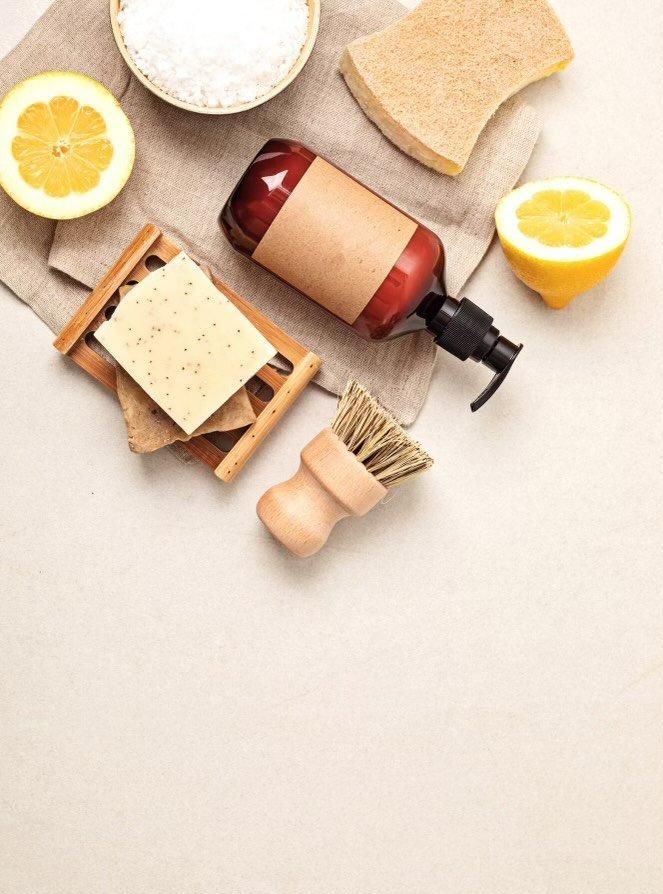 A bottle of soap , a brush , sponges , and lemons on a table. — The Home Assembly In Avoca Beach, NSW