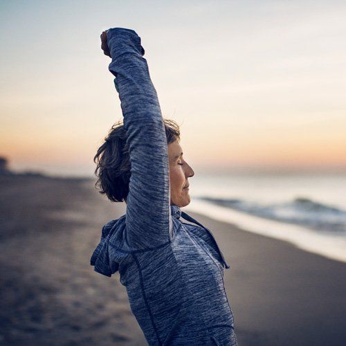 woman stretching on beach