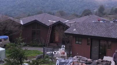 The image of a home in Walnut Creek, CA, being serviced by a roofing contractor