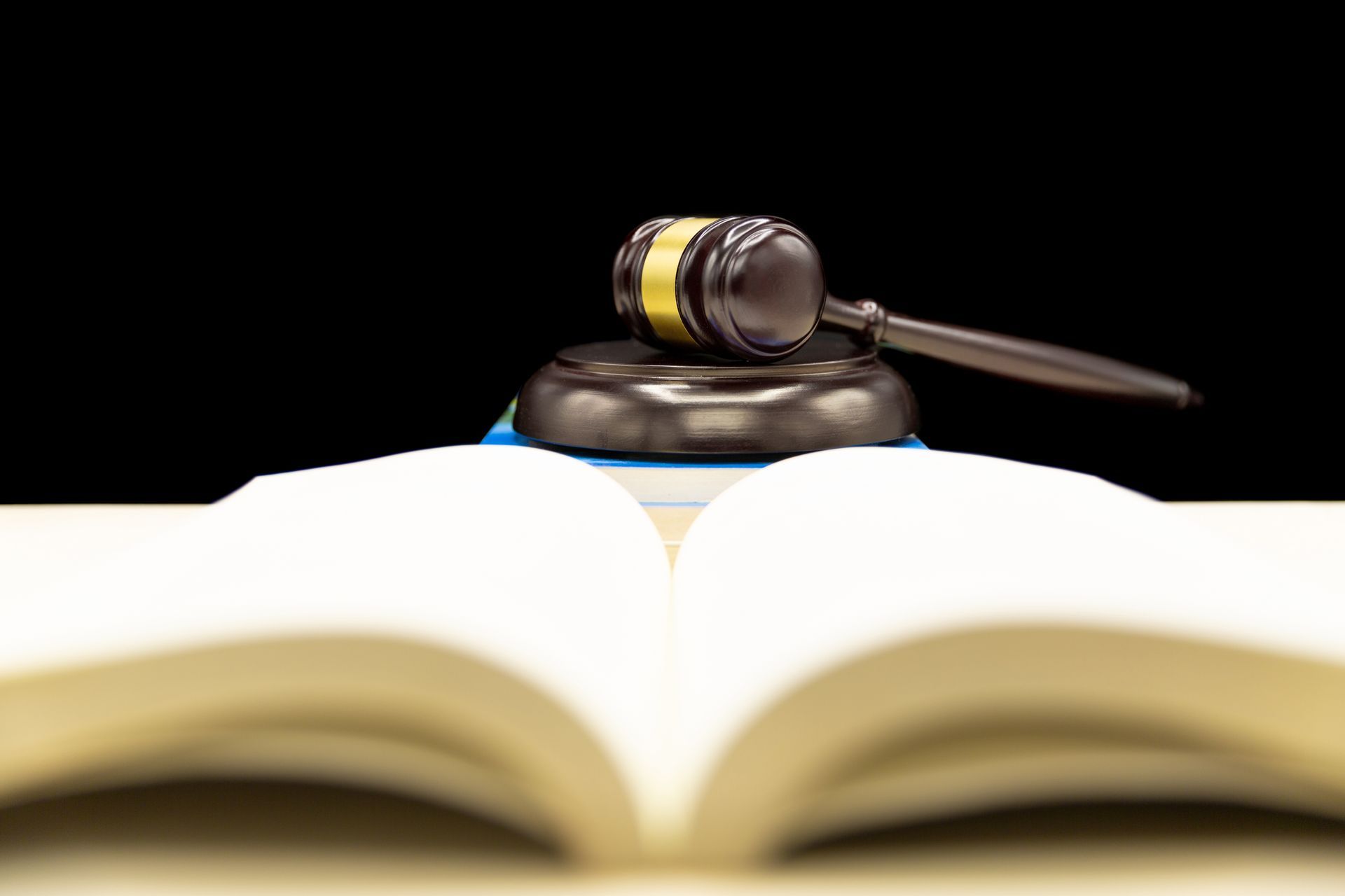 A man is sitting at a table with a wooden family and a gavel.