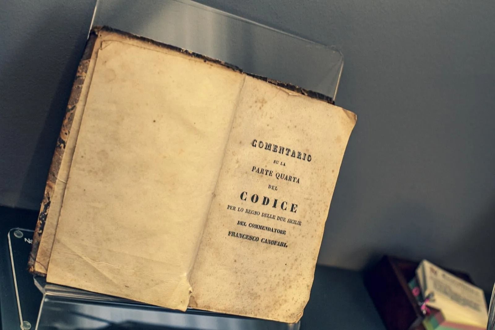 Libro antico aperto con testo, esposto.