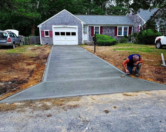 Concrete worker putting the finishing touches on a concrete driveway leading up to a house in Peterborough.