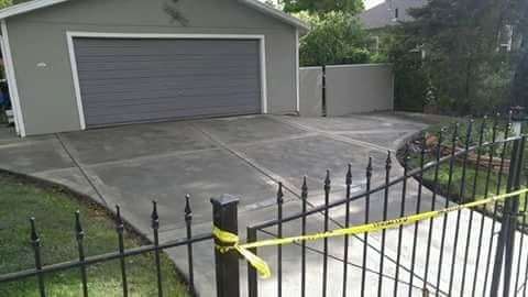 Freshly completed stamped concrete driveway in front of a detached garage.