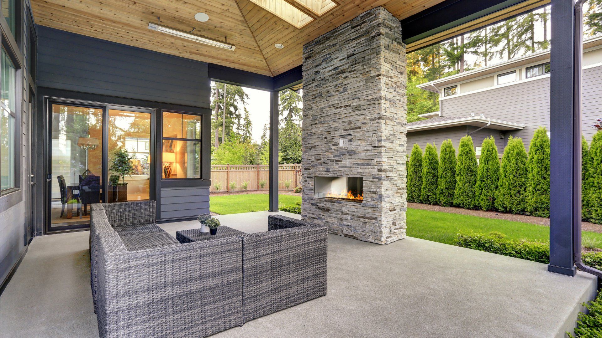 Covered outdoor patio with a brick fireplace and outdoor furniture. The patio is a concrete slab.
