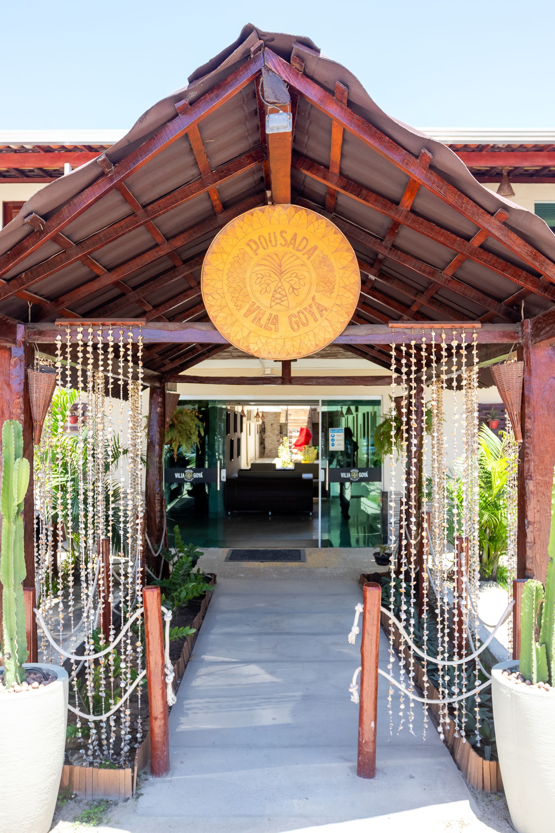 Entrada de madeira para um edifício, com uma placa e cordões decorativos de contas.