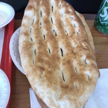 A person is cooking meat on a grill with chopsticks.