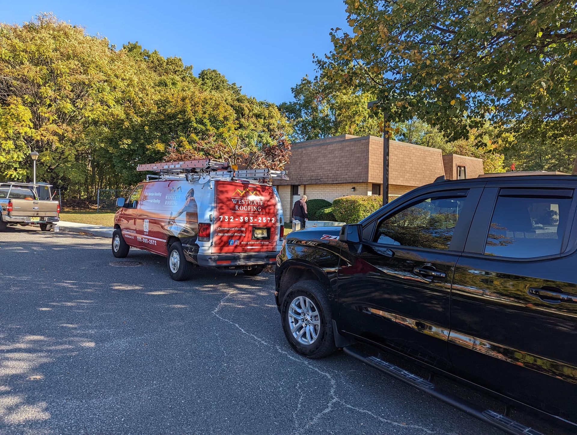 Woman in straw hat smiles, holding wine glass near a lake.