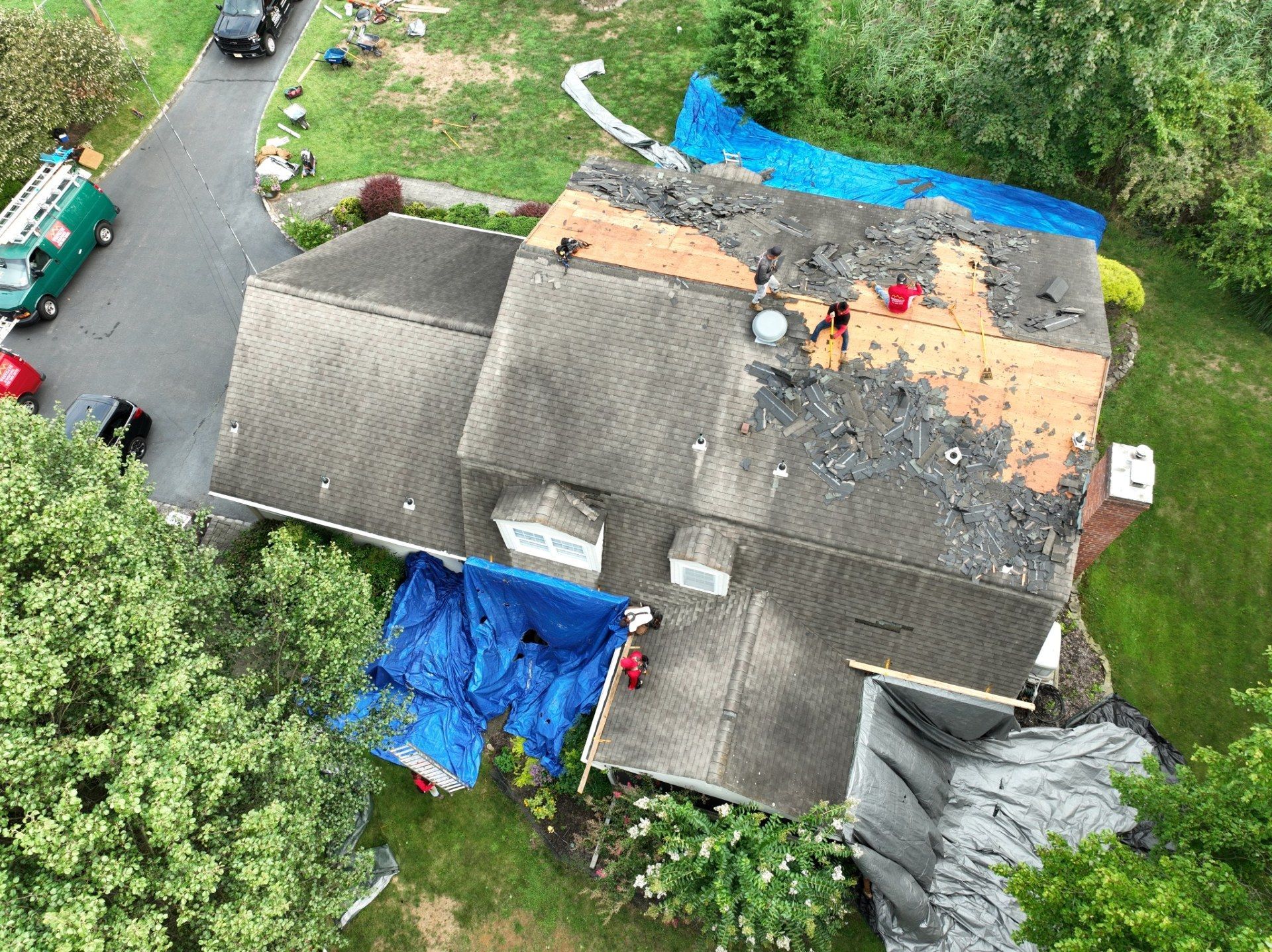 Woman in straw hat smiles, holding wine glass near a lake.