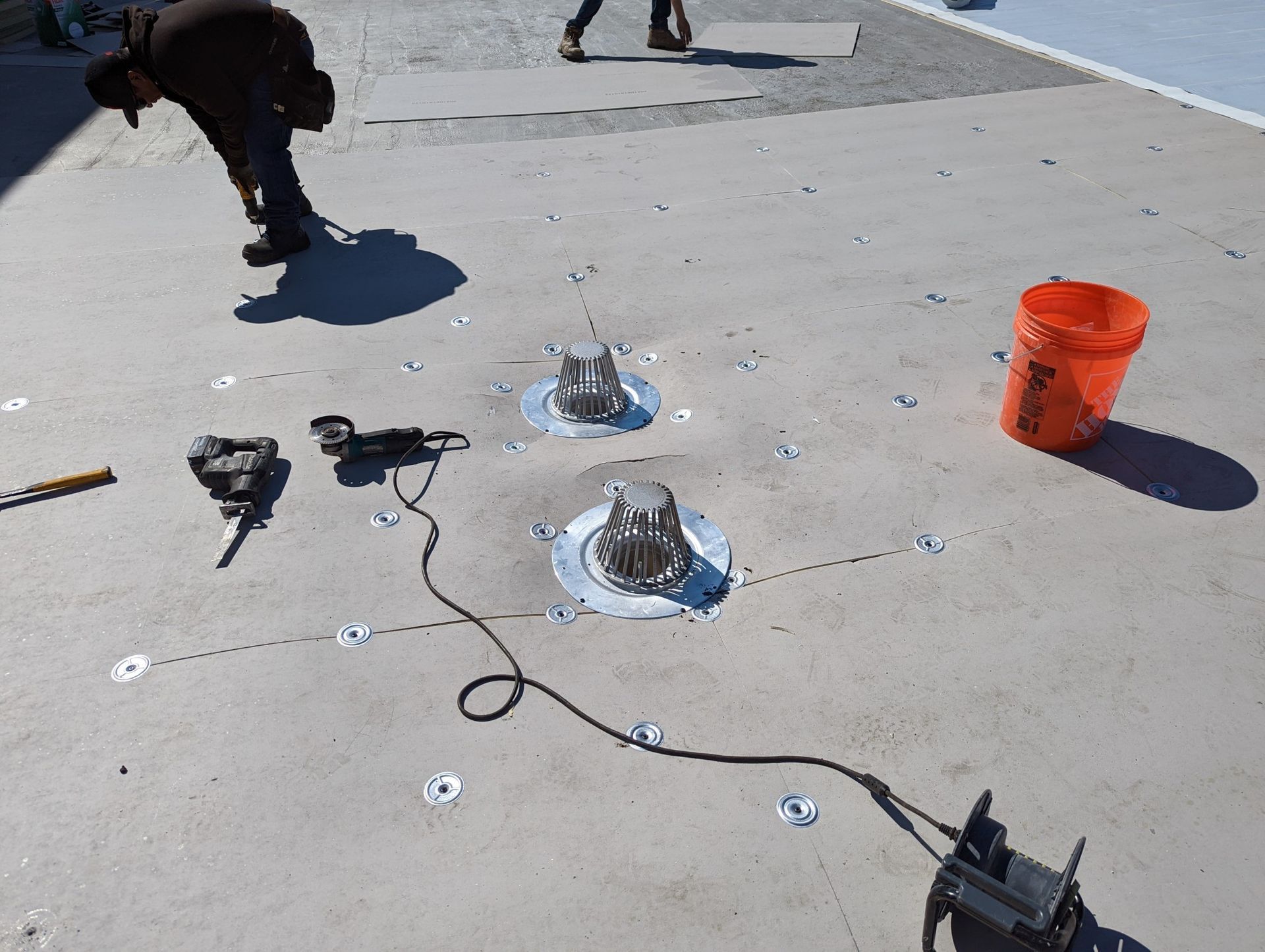 Woman in straw hat smiles, holding wine glass near a lake.