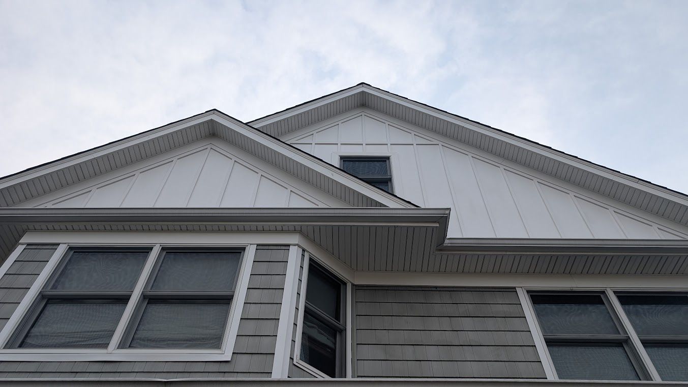 Woman in straw hat smiles, holding wine glass near a lake.