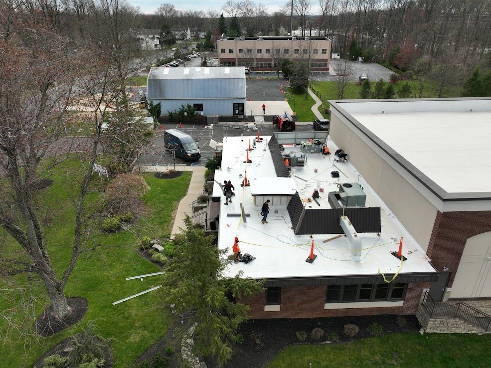 Woman in straw hat smiles, holding wine glass near a lake.