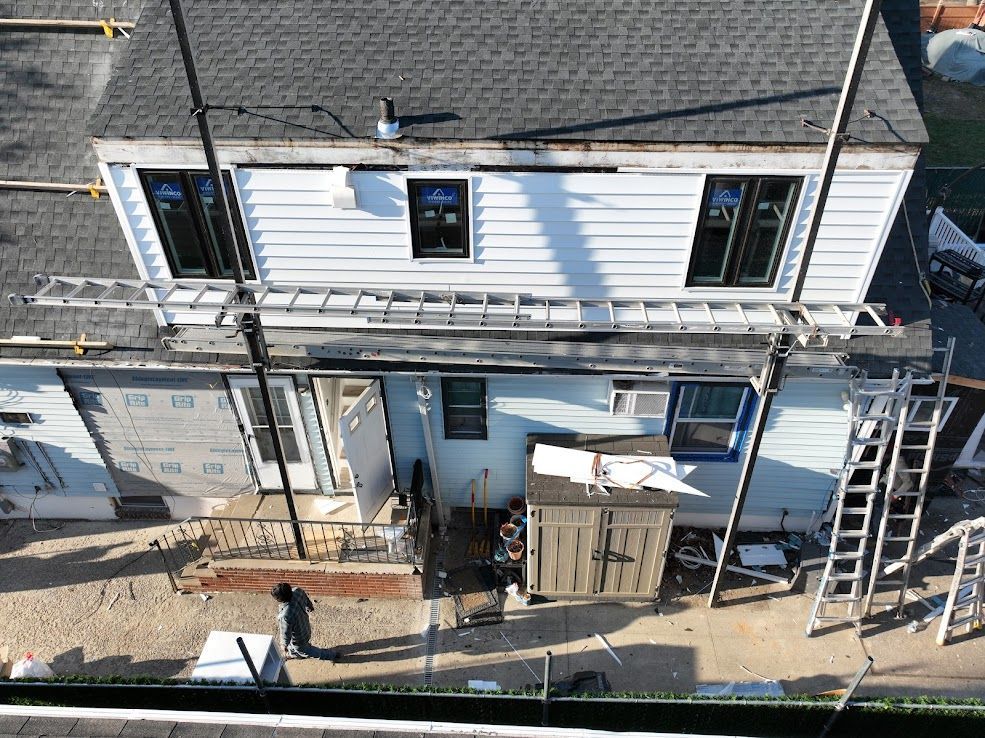 Overhead view of a house undergoing renovations, ladders, and scaffolding visible.