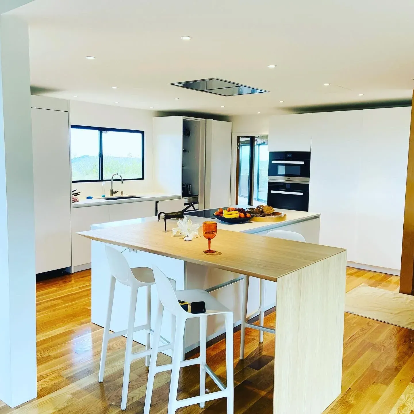 A kitchen with a table and stools in it