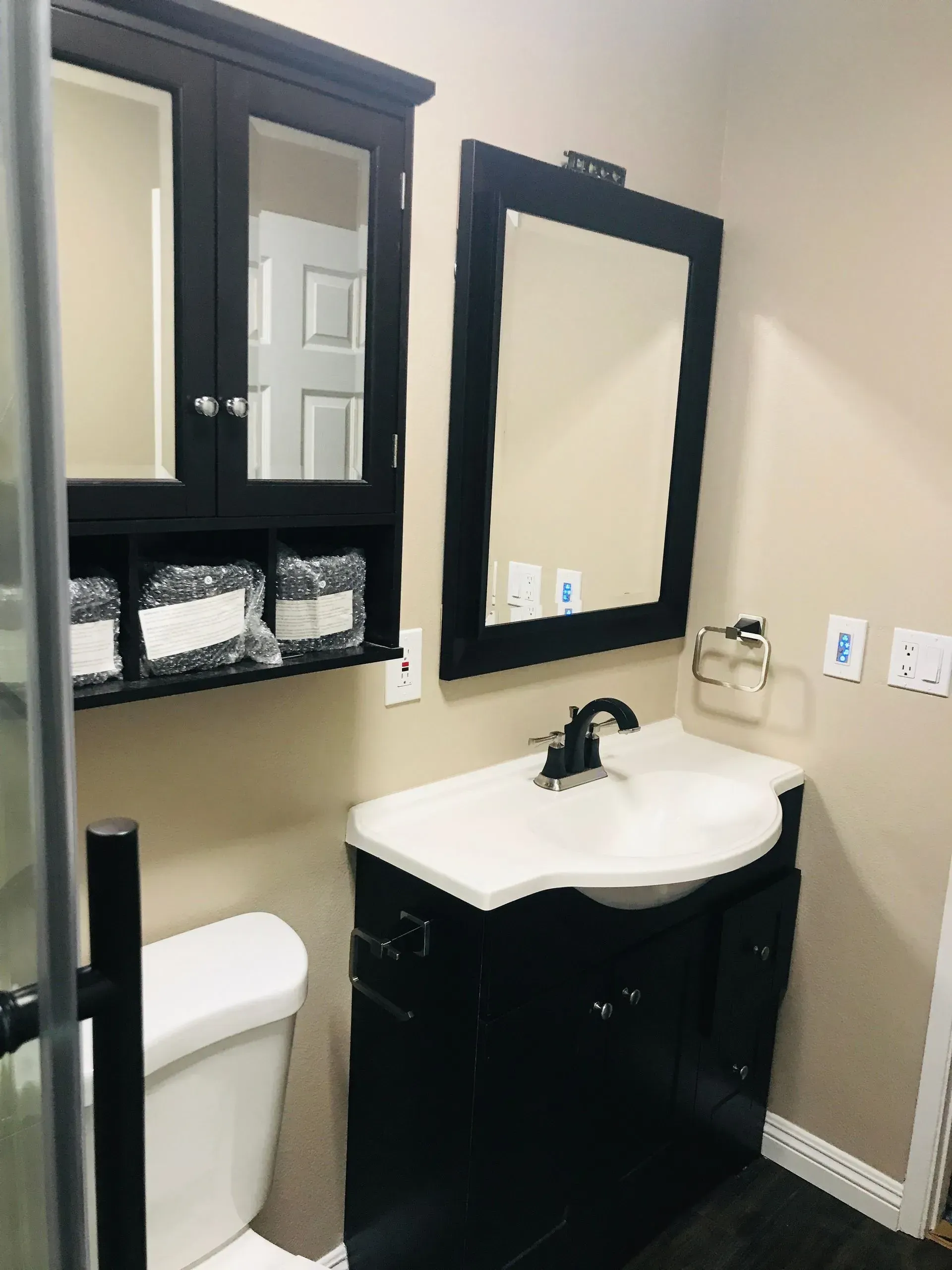 A bathroom with a toilet a sink and two mirrors