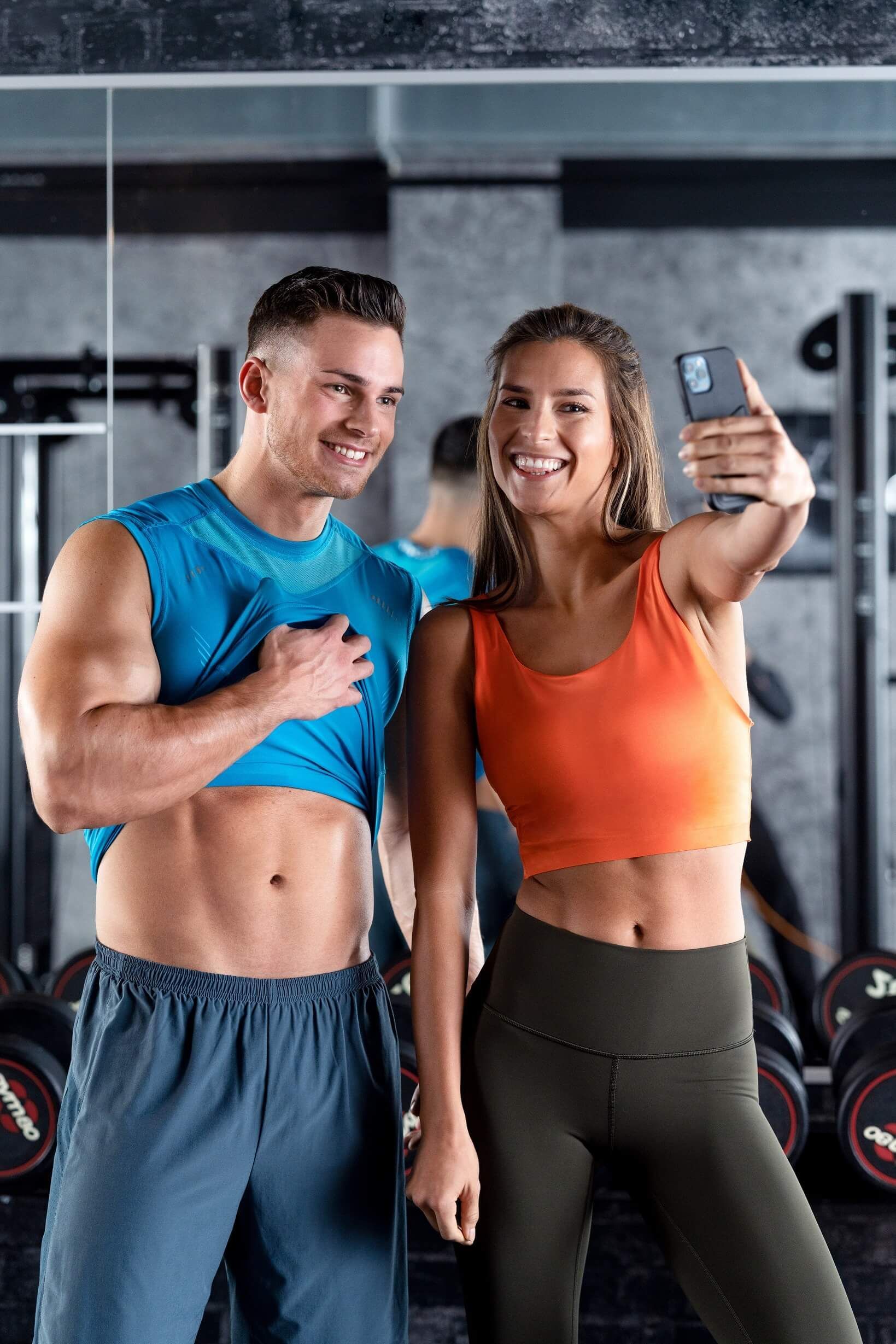 Uśmiechnięta para robi zdjęcia na siłowni