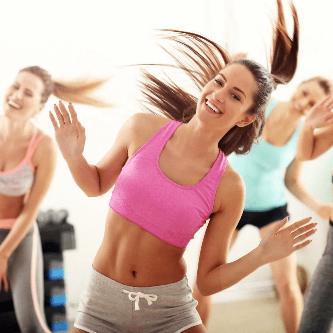 Uśmiechnięte kobiety tańczące na siłowni