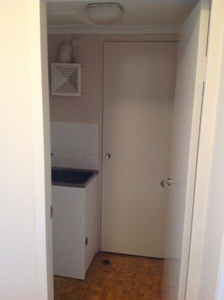 A Laundry Room With a Sink and a Door — Dowdy Constructions in Forster, NSW