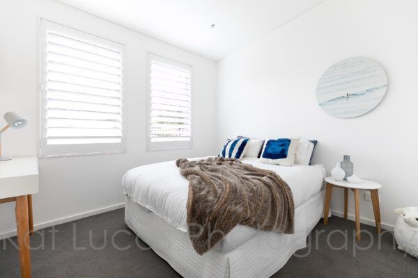 A Bedroom With a Bed and a Clock on the Wall — Dowdy Constructions in Forster, NSW
