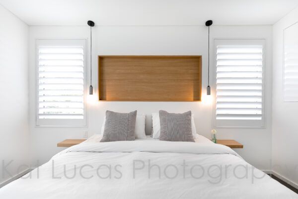 A Bedroom With a Bed and a Wooden Headboard — Dowdy Constructions in Forster, NSW