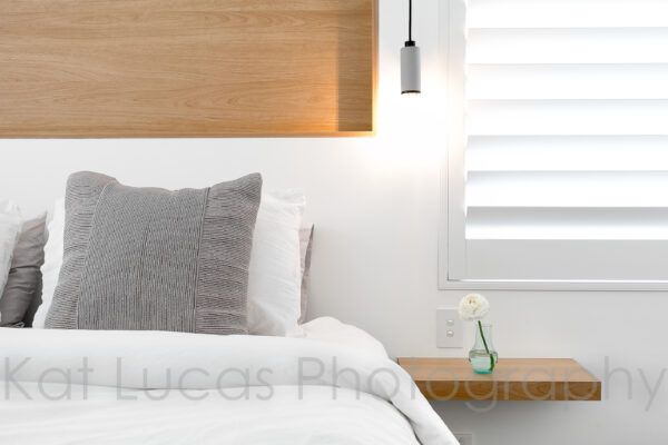 A Bed With White Sheets and Grey Pillows in a Bedroom — Dowdy Constructions in Forster, NSW