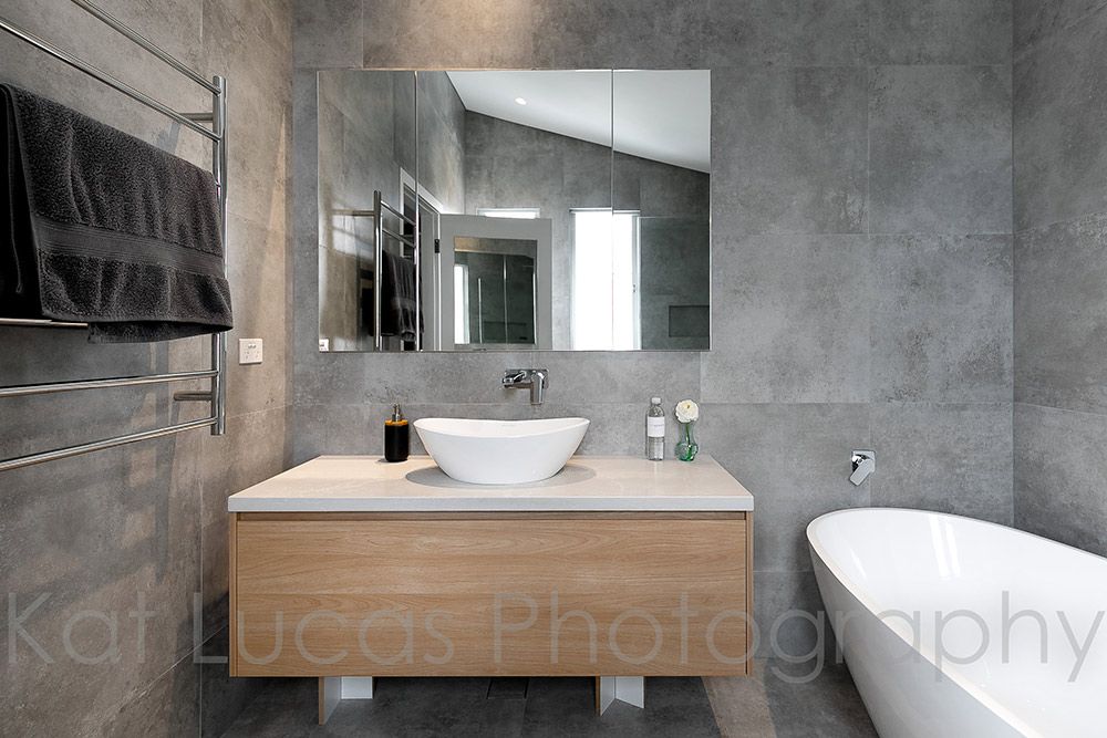 A Bathroom With a Sink, Bathtub and Mirror — Dowdy Constructions in Forster, NSW