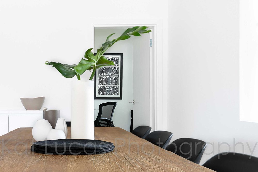 A Dining Room Table With a Vase of Plants on It — Dowdy Constructions in Forster, NSW