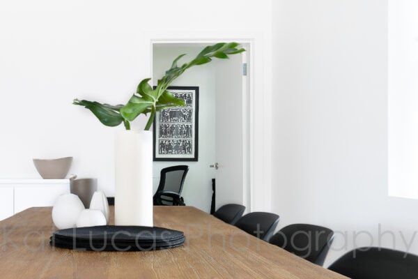 A Dining Room Table With a Vase of Plants on It — Dowdy Constructions in Forster, NSW