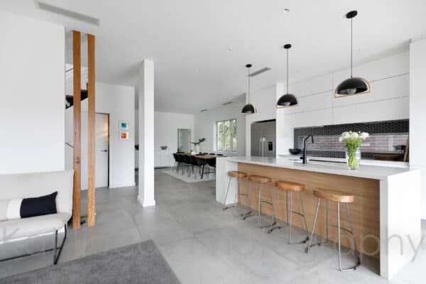 A Kitchen With a Large Island and Stools — Dowdy Constructions in Forster, NSW