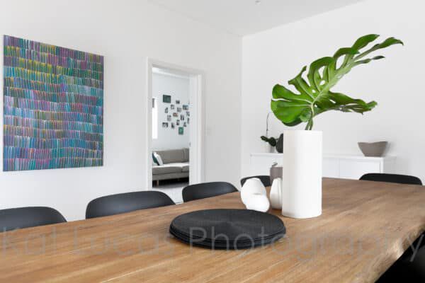 A Dining Room Table With a Plant in a Vase on It — Dowdy Constructions in Forster, NSW