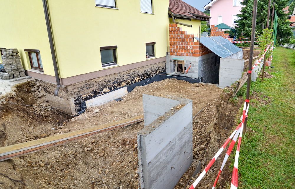 A Yellow House is Being Built Next to a Large Pile of Dirt — Dowdy Constructions in Tuncurry, NSW