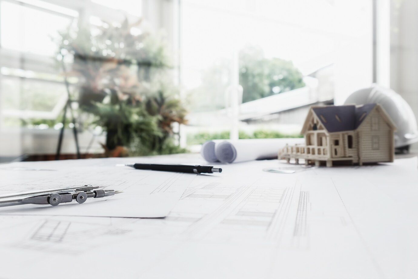A Model House is Sitting on Top of a Table Next to a Hard Hat — Dowdy Constructions in Forster, NSW