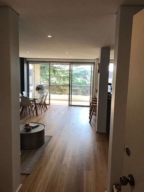 A Living Room With a Table and Chairs and a Sliding Glass Door — Dowdy Constructions in Forster, NSW