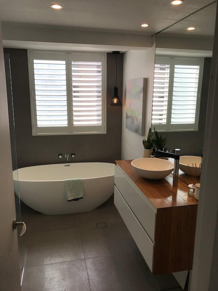 A Bathroom With a Tub, Sink and Mirror — Dowdy Constructions in Forster, NSW