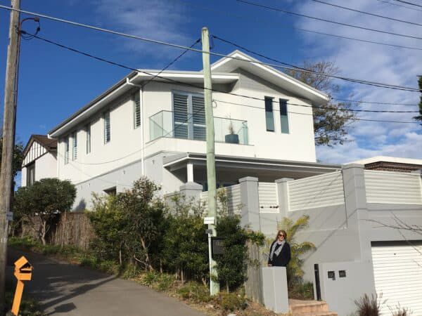 A Large White House is Sitting on Top of a Hill — Dowdy Constructions in Forster, NSW