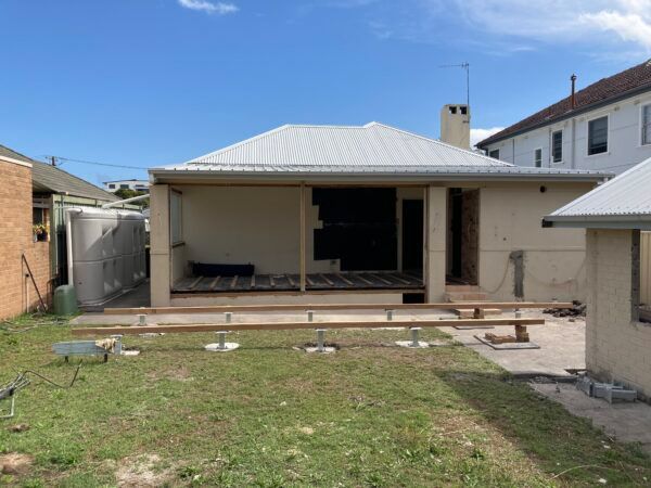 A House With a White Roof is Being Remodeled in a Backyard — Dowdy Constructions in Forster, NSW
