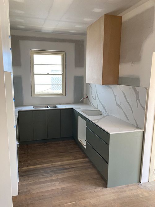 A Kitchen With a Sink, Cabinets, Counter Tops and a Window — Dowdy Constructions in Forster, NSW