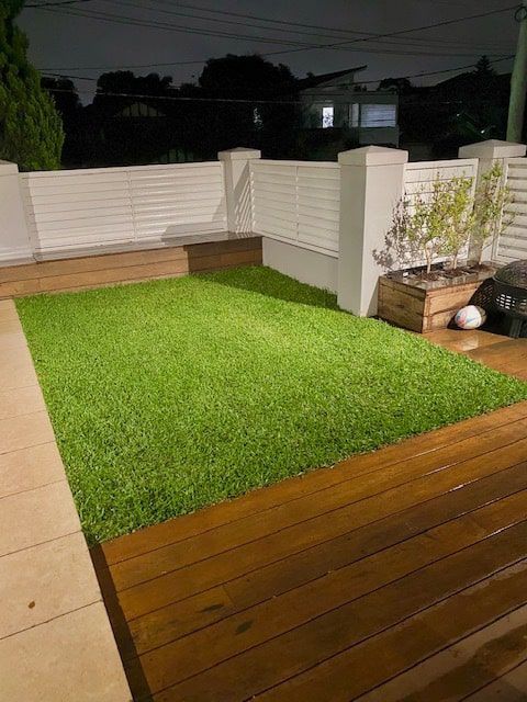 A Wooden Deck With a Large Green Rug on It — Dowdy Constructions in Forster, NSW