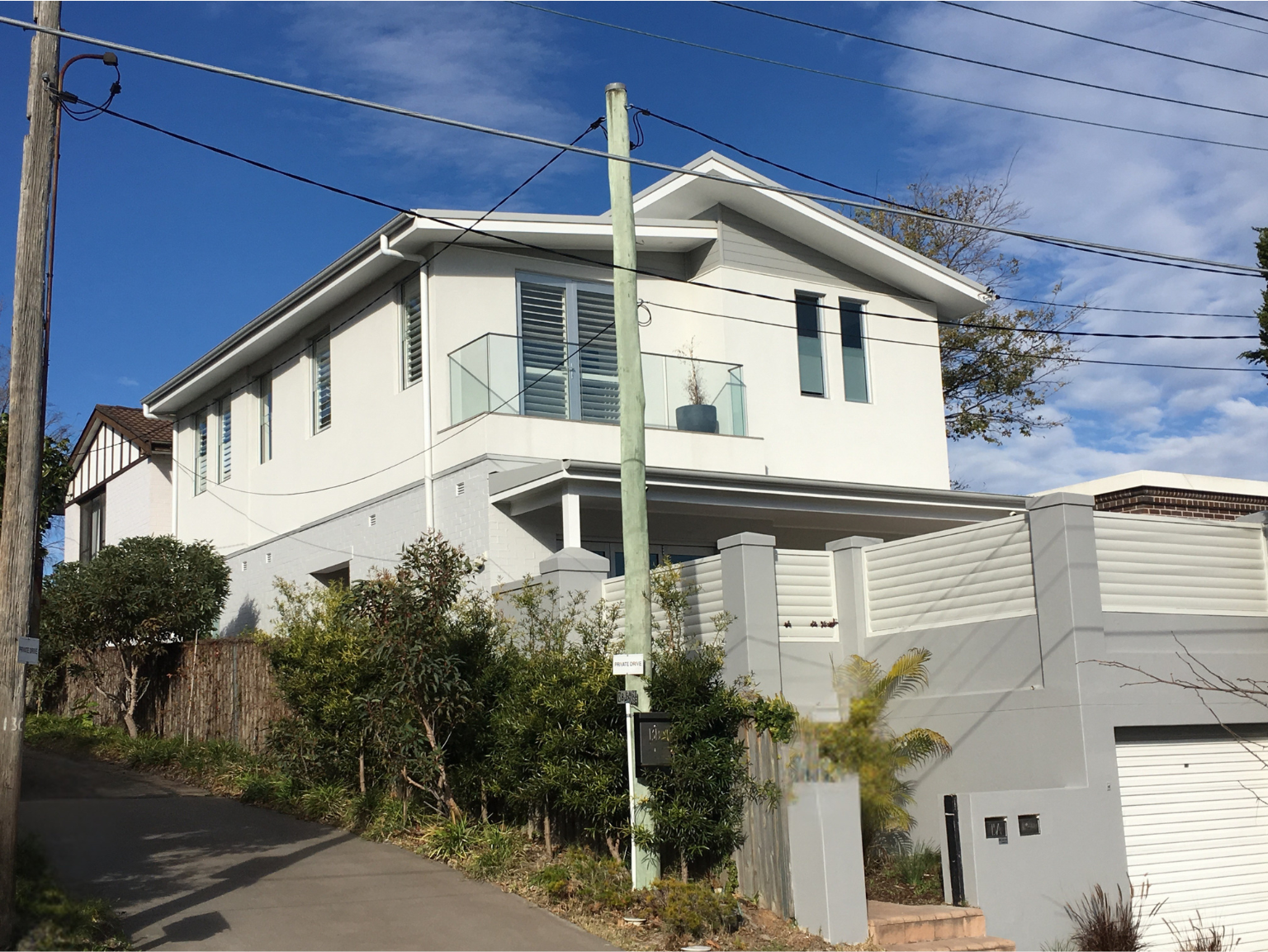 A Large White House is Sitting on Top of a Hill Next to a Mailbox — Dowdy Constructions in Forster, NSW