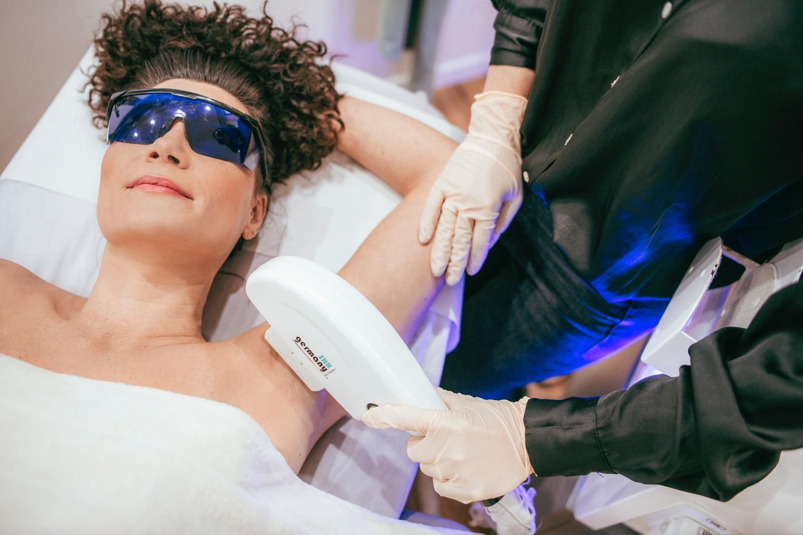 Eine Frau lässt sich an den Achseln eine Laser-Haarentfernung durchführen.