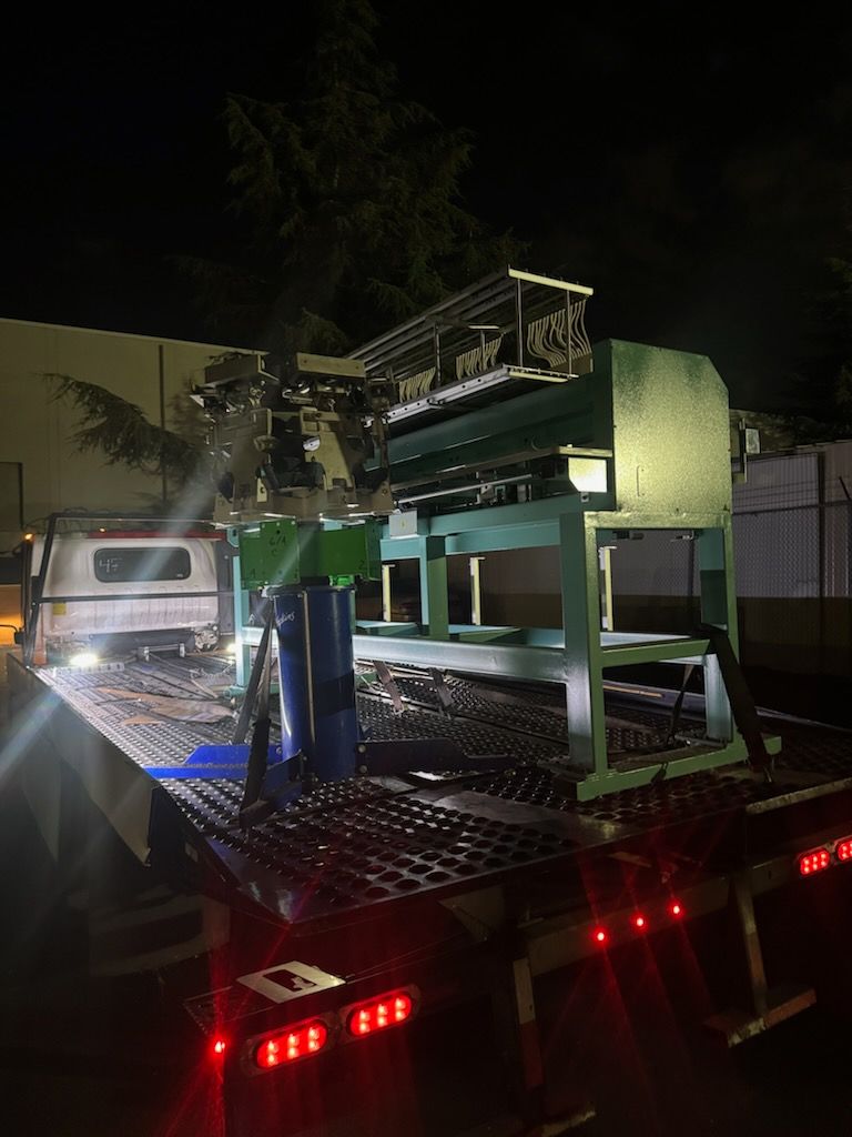 An industrial machine loaded on a flatbed tow truck