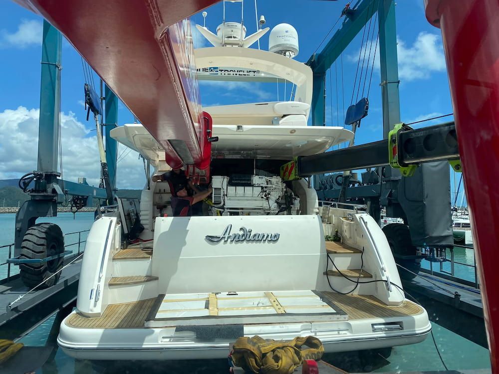 A Man is Working on the Engine of a Boat — Whitsunday Diesel & Marine In Townsville, QLD